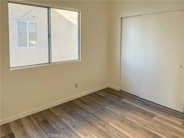 a view of a small space with wooden floor and a window