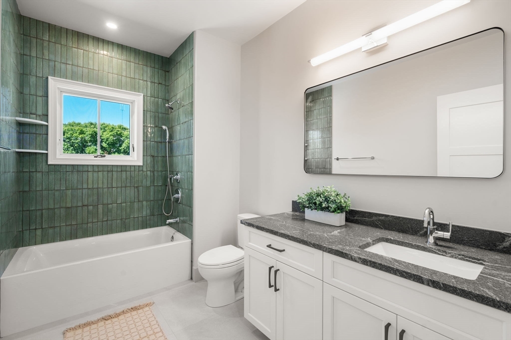 69 Williams Street, Unit 3 Boston, MA 02130 - Photo 19 of 22 a bathroom with a granite countertop sink mirror and bathtub