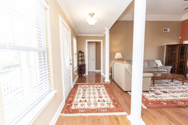 a view of a hallway with wooden floor and a large window