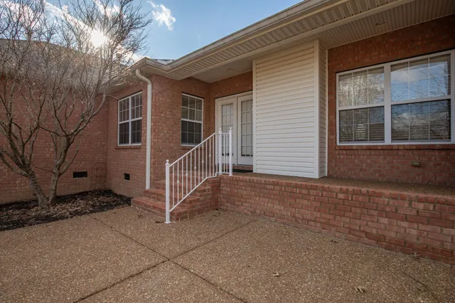 a front view of house with yard and trees around