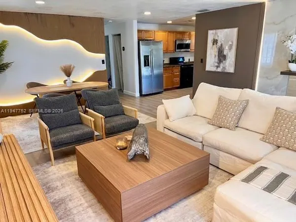 a living room with furniture wooden floor and a large window