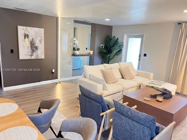 a living room with furniture and wooden floor