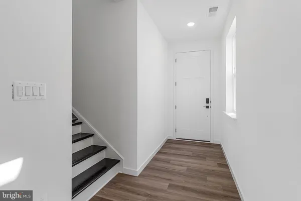 a view of a hallway with wooden floor and entryway