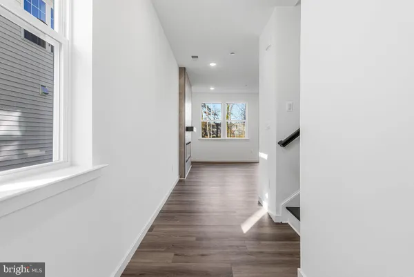 a view of a hallway with wooden floor and a living room