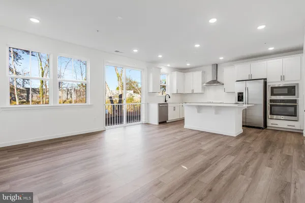 a view of a kitchen with wooden floor and electronic appliances