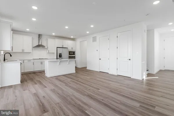a view of kitchen with wooden floor and electronic appliances