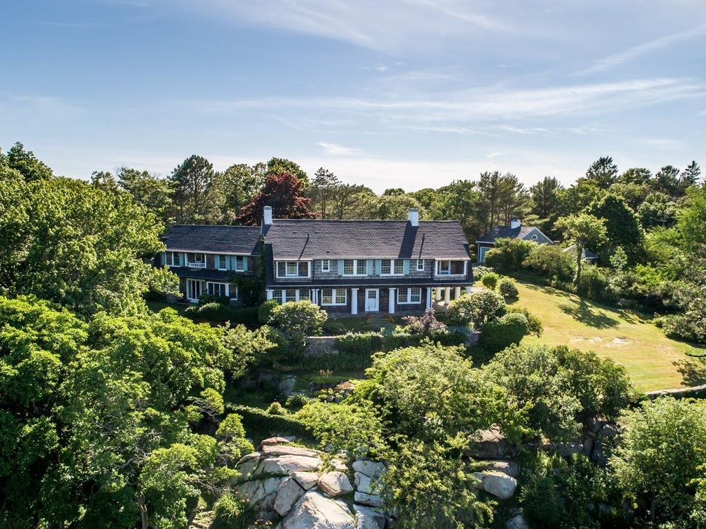 a view of a big house with a big yard plants and large trees