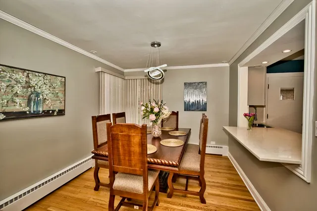 a view of a dining room with furniture a chandelier and wooden floor