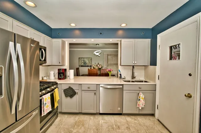 a kitchen with white cabinets and stainless steel appliances