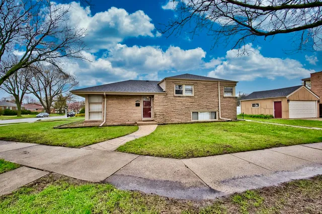 a front view of a house with a garden and yard