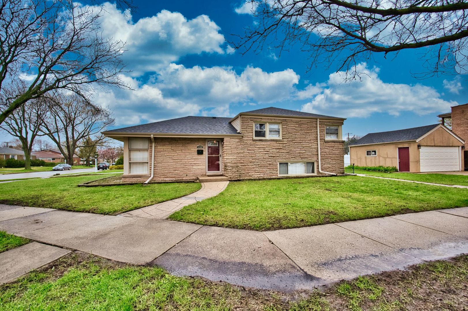 5200 Madison Street Skokie, IL 60077 - Photo 4 of 53 a front view of a house with a garden and yard