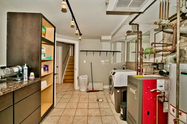 a living room with furniture and a refrigerator