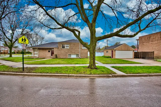 a view of a house with a big yard plants and large trees