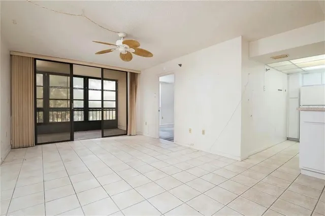 an empty room with windows and fan