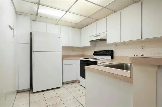 a kitchen with a refrigerator sink and cabinets