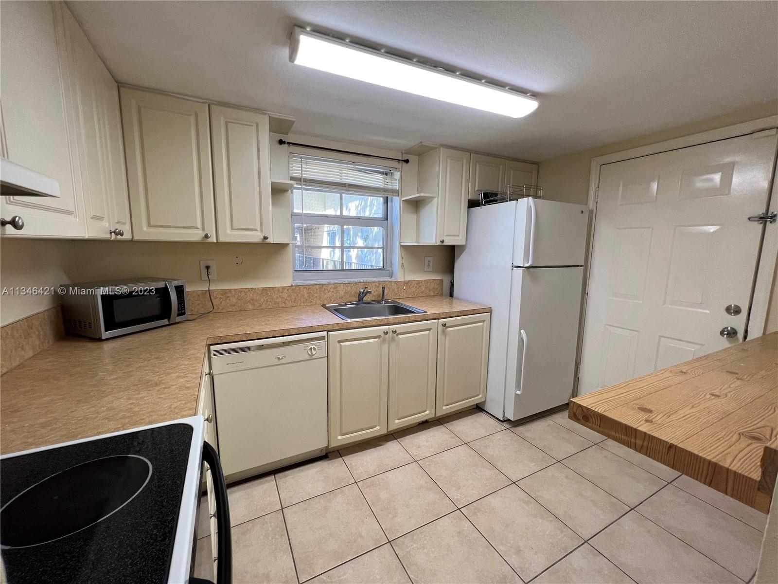 8600 Southwest 109th Avenue, Unit 4209 Miami, FL 33173 - Photo 6 of 15 a kitchen with a refrigerator a stove a sink and cabinets
