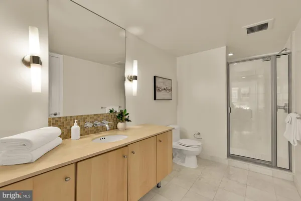 a bathroom with a double vanity sink toilet and shower