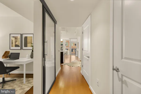 a view of a hallway with bathroom and wooden floor