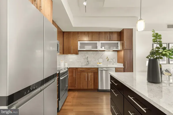 a kitchen with granite countertop a sink stainless steel appliances and cabinets