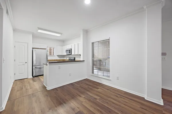 a kitchen with wooden floors and white cabinets