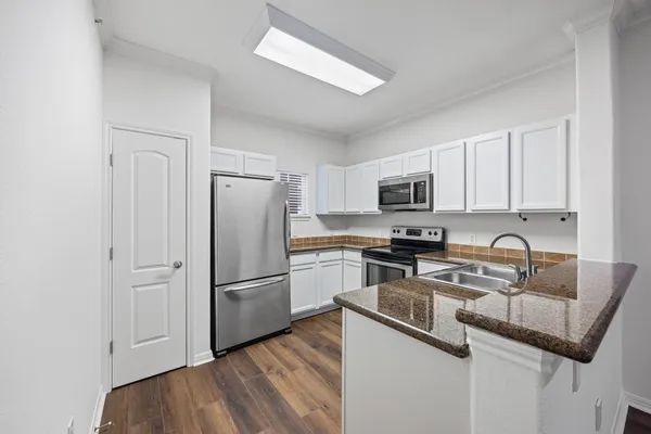 a kitchen with stainless steel appliances granite countertop a refrigerator stove and sink