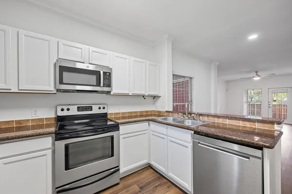a kitchen with stainless steel appliances granite countertop a sink stove oven microwave and cabinets