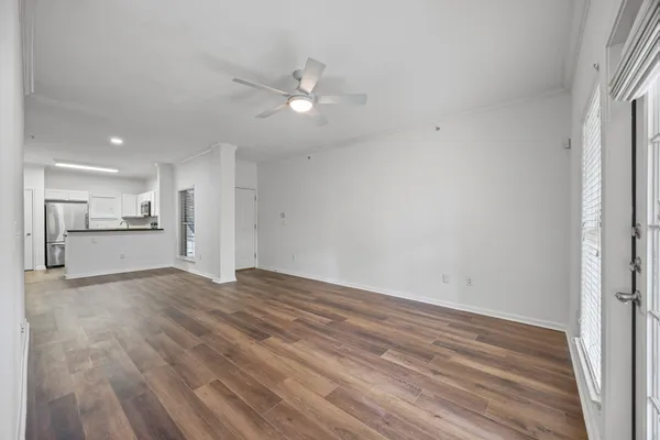 a view of empty room with wooden floor and window