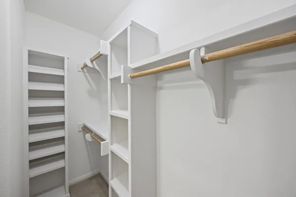 a view of walk in closet with empty racks