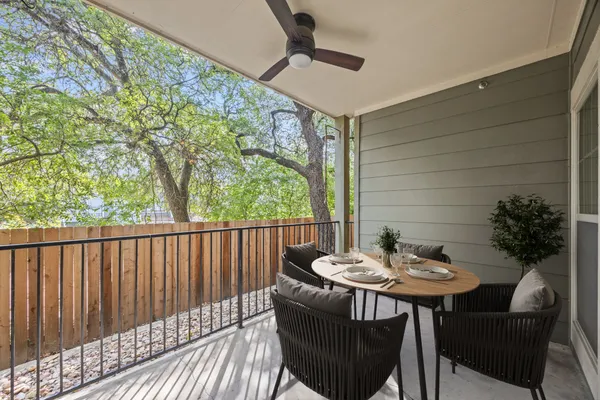 a view of a patio with a table and chairs and a barbeque