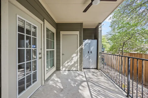 a view of a balcony with wooden floor and fence