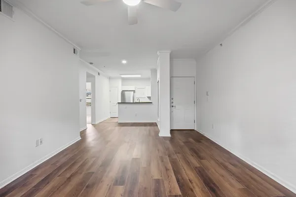 wooden floor in an empty room with a kitchen