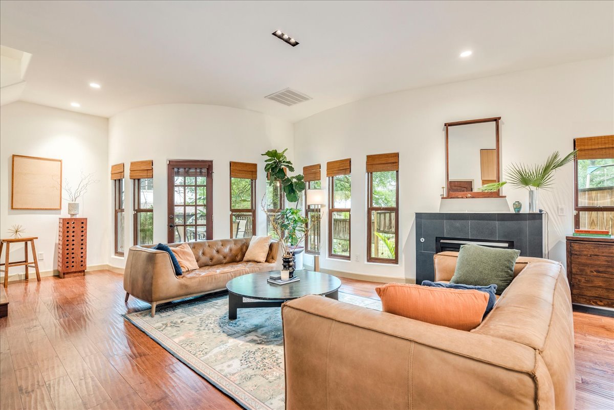 3012 South 4th Street, Unit B Austin, TX 78704 - Photo 4 of 40 Spacious living area featuring wood-finish flooring, recessed lighting, and multiple windows with natural wood trim