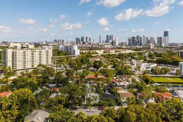 a bedroom with a bed a flat screen tv and a large window