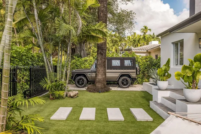 a living room with furniture a chandelier and a dining table