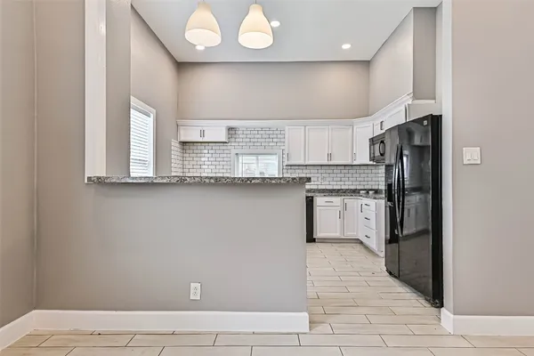 a kitchen with stainless steel appliances granite countertop a refrigerator a sink and a stove