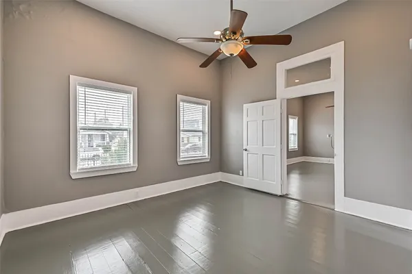a view of an empty room with a window and wooden floor