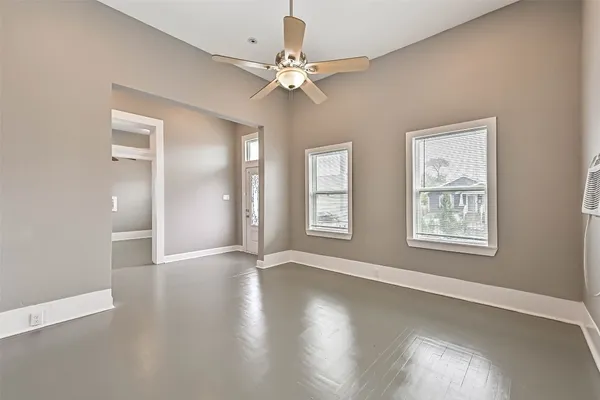 a view of an empty room with window and wooden floor