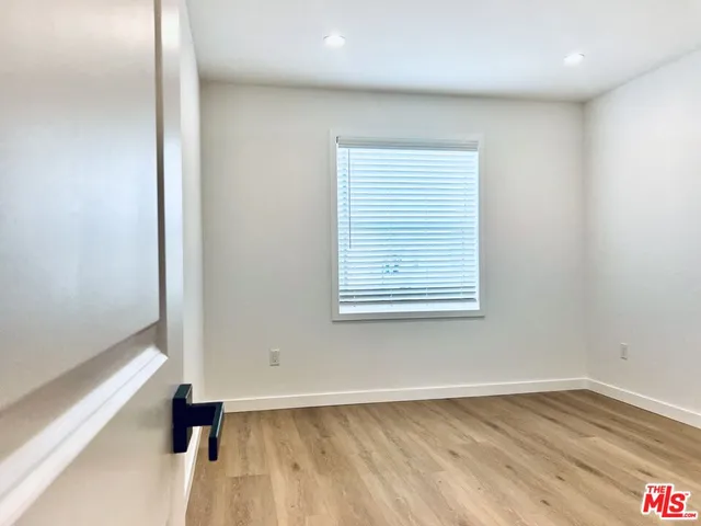 an empty room with wooden floor and a window