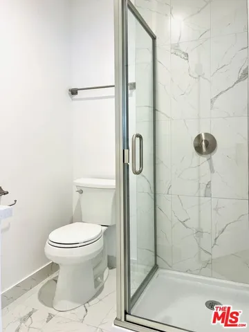 a bathroom with a toilet and a shower
