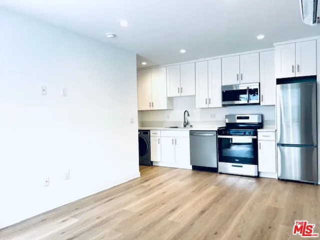 a kitchen with a refrigerator and a stove top oven