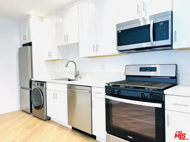 a kitchen with stainless steel appliances a stove microwave and refrigerator