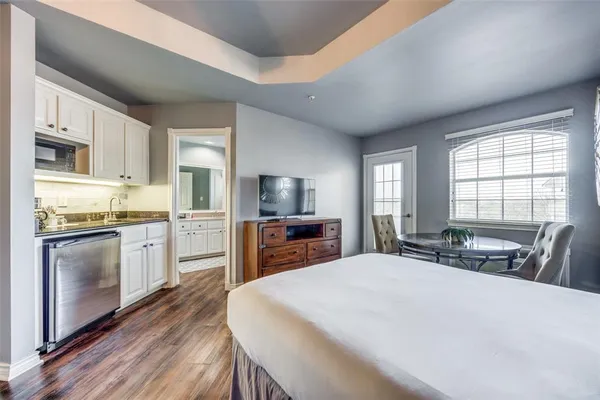 a large kitchen with sink a microwave refrigerator and cabinets