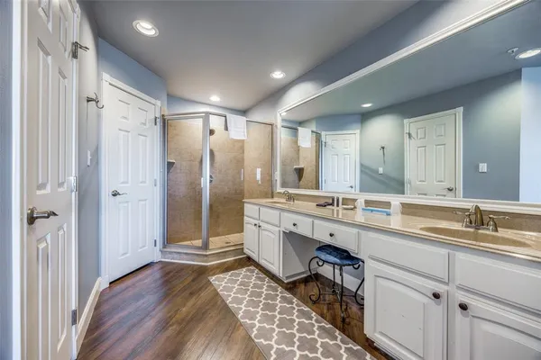 a bathroom with a double vanity sink mirror and shower