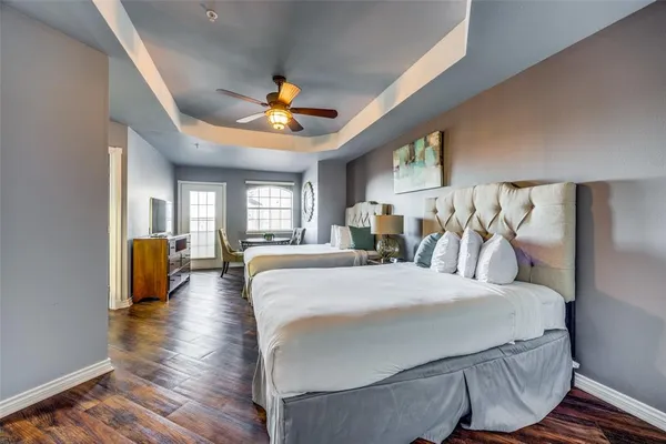 a large bedroom with a bed and wooden floor