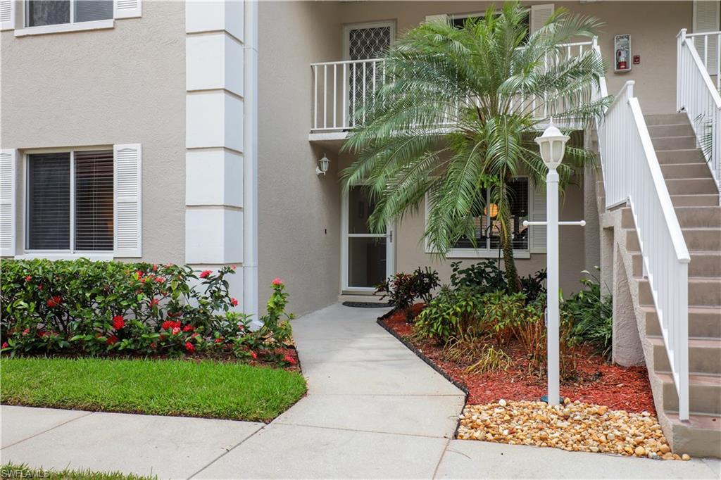 6740 Dennis Circle, Unit B103 Naples, FL 34104 - Photo 1 of 16 a front view of yellow house with flower plants
