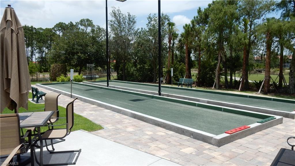6740 Dennis Circle, Unit B103 Naples, FL 34104 - Photo 12 of 16 a view of a tennis court with chairs