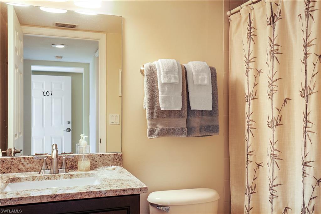 6740 Dennis Circle, Unit B103 Naples, FL 34104 - Photo 9 of 16 a bathroom with a granite countertop sink and a mirror