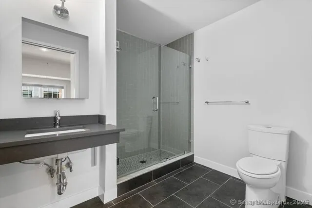 a bathroom with a sink toilet vanity and shower