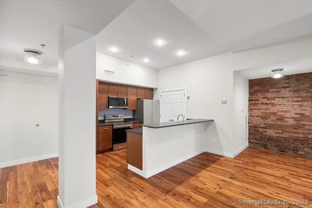 a kitchen with stainless steel appliances granite countertop a refrigerator and a stove