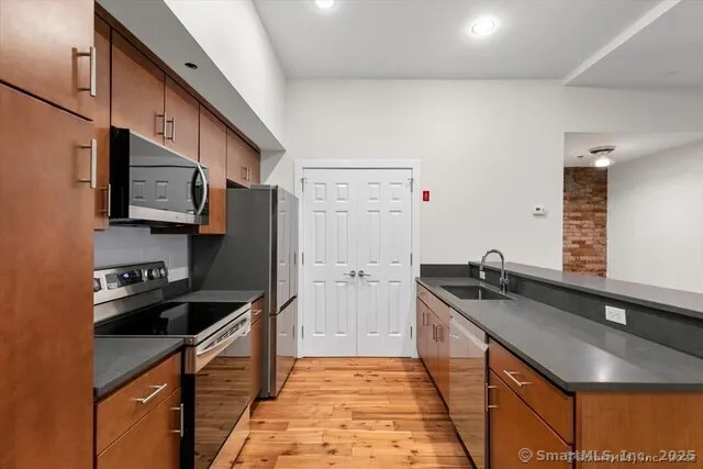 a kitchen with granite countertop a sink stove and refrigerator